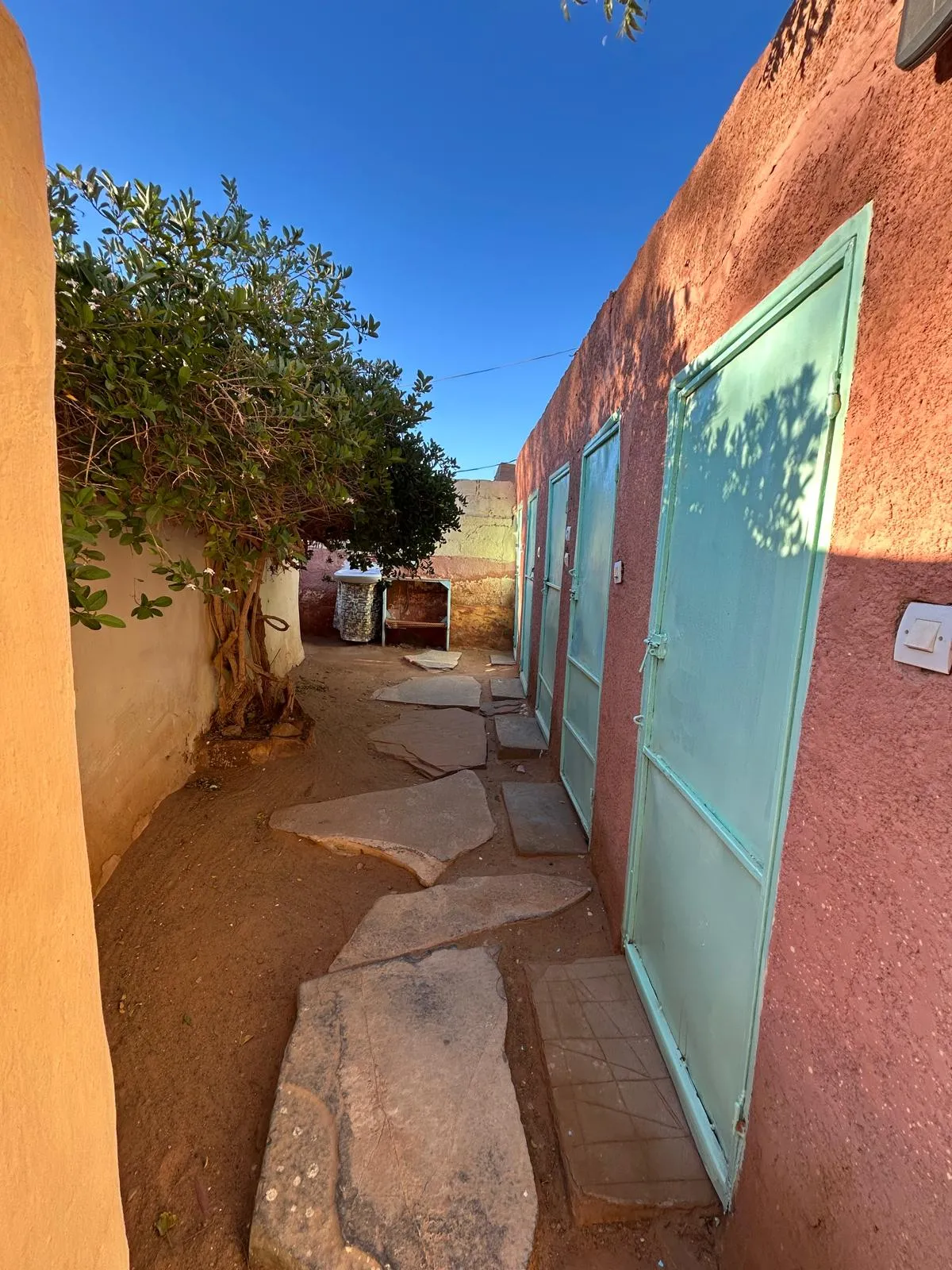 Allée entre les chambres aux portes turquoise